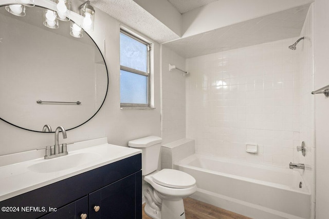 full bathroom with hardwood / wood-style flooring, vanity, toilet, and tiled shower / bath