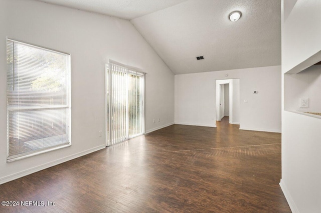 unfurnished living room featuring a textured ceiling, dark hardwood / wood-style flooring, and lofted ceiling