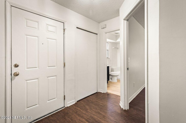 hall featuring dark hardwood / wood-style floors and a textured ceiling