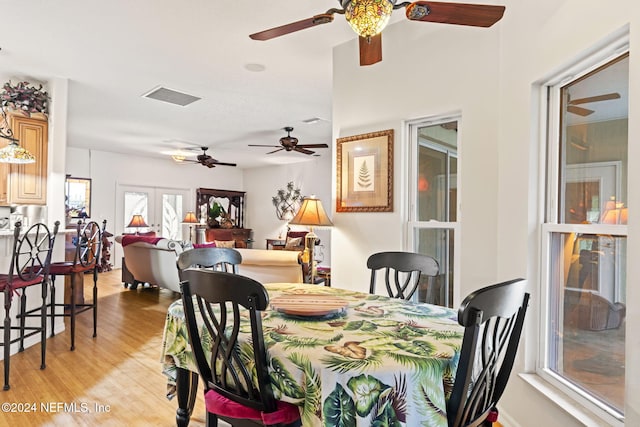 dining space with light hardwood / wood-style floors and french doors