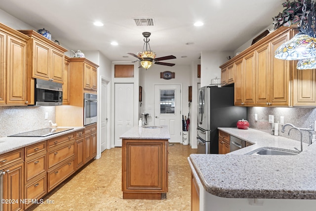 kitchen featuring decorative backsplash, stainless steel appliances, a kitchen island, and sink