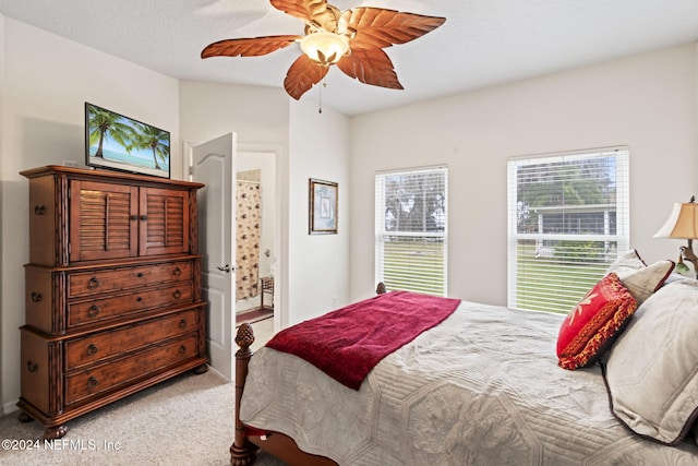 carpeted bedroom featuring ceiling fan and a textured ceiling