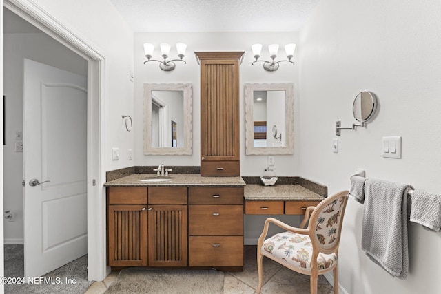 bathroom featuring vanity, a chandelier, and a textured ceiling