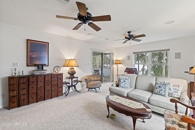 living room featuring ceiling fan, carpet floors, and a textured ceiling