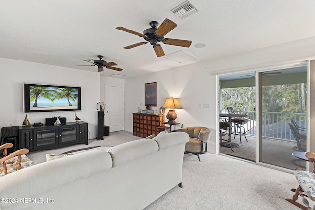 carpeted living room with a textured ceiling and ceiling fan