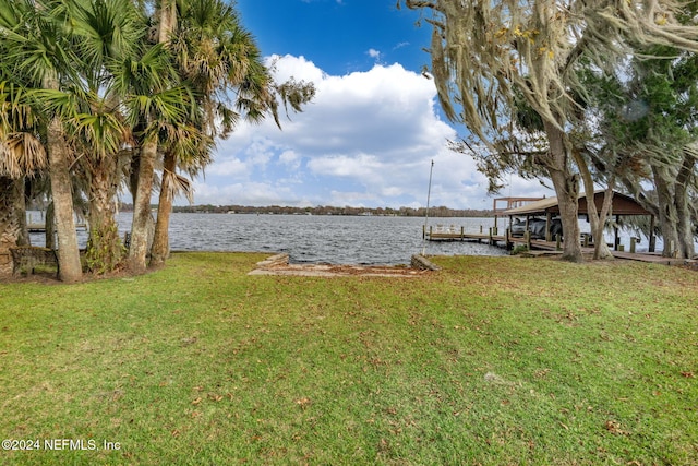 view of yard featuring a water view and a dock