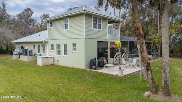 rear view of house with a lawn, cooling unit, a patio area, and a balcony