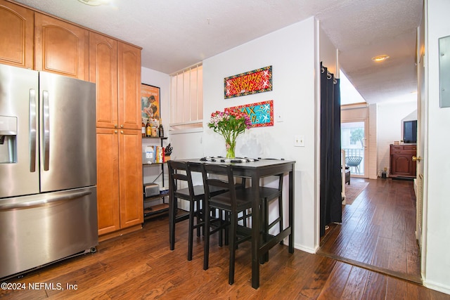 dining room with dark hardwood / wood-style floors and a textured ceiling