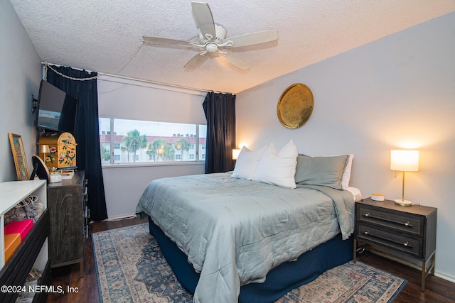 bedroom featuring ceiling fan, dark hardwood / wood-style floors, and a textured ceiling