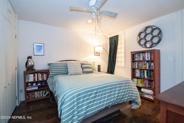 bedroom featuring a textured ceiling, ceiling fan, and dark hardwood / wood-style floors