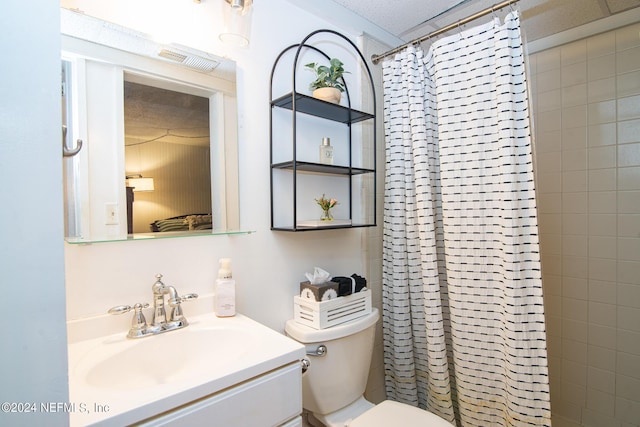 bathroom with a shower with curtain, vanity, a textured ceiling, and toilet