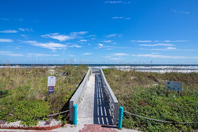 view of property's community with a water view and a view of the beach