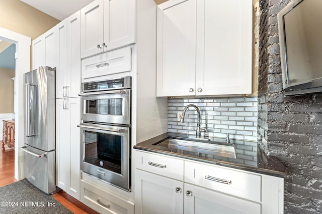 kitchen with white cabinets, stainless steel appliances, dark wood-type flooring, and sink