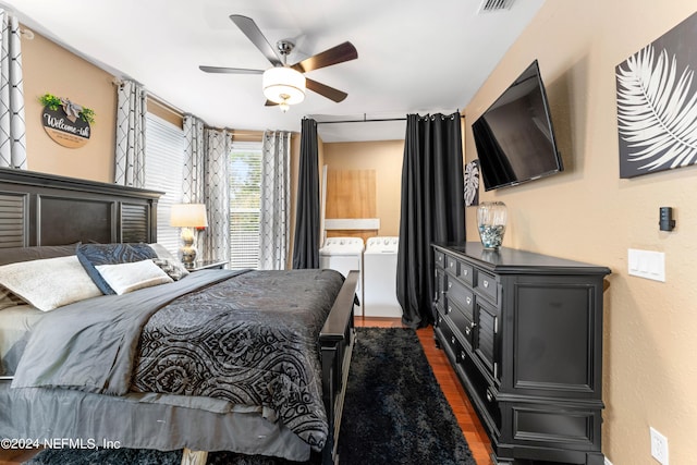 bedroom featuring dark hardwood / wood-style floors, ceiling fan, and washing machine and clothes dryer