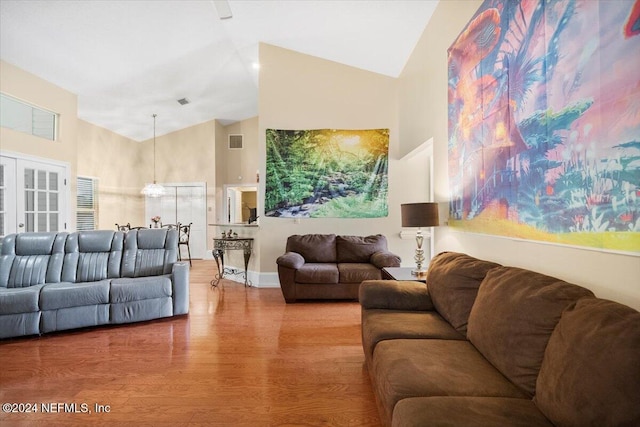 living room with french doors, high vaulted ceiling, and wood-type flooring