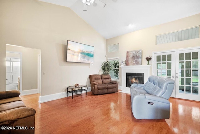 living room featuring a wealth of natural light, hardwood / wood-style floors, high vaulted ceiling, and french doors