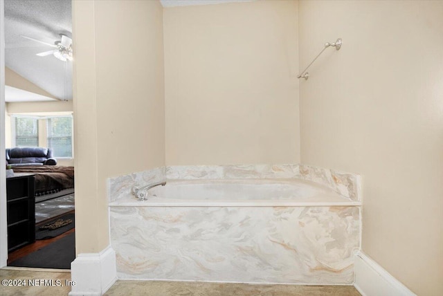 bathroom featuring a textured ceiling, ceiling fan, and a tub