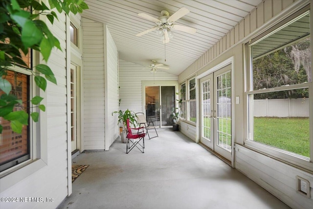 unfurnished sunroom featuring vaulted ceiling, ceiling fan, and a healthy amount of sunlight