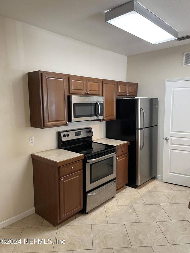 kitchen with appliances with stainless steel finishes and light tile patterned floors