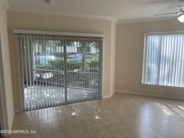 spare room featuring a wealth of natural light, ceiling fan, light tile patterned floors, and ornamental molding