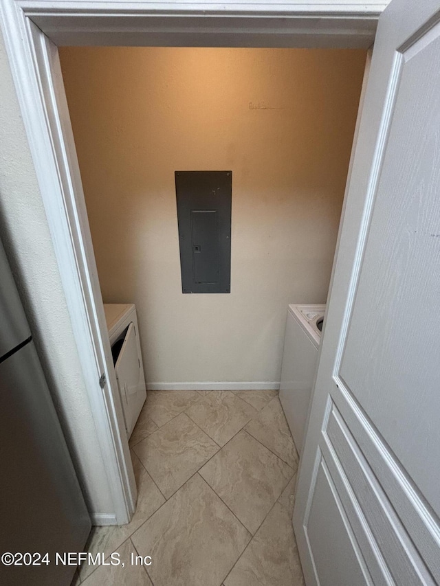 washroom featuring separate washer and dryer, light tile patterned floors, and electric panel