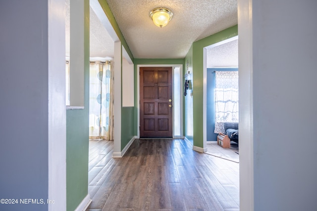 foyer entrance with hardwood / wood-style floors and a textured ceiling