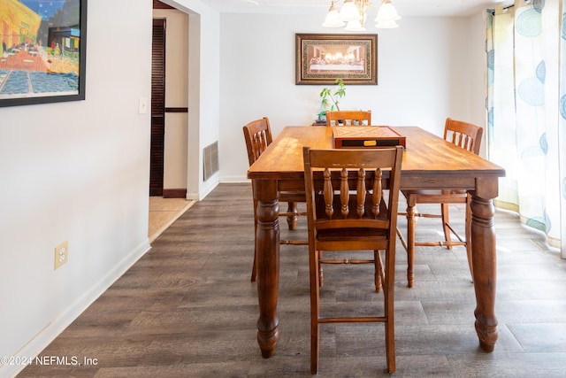 dining space featuring hardwood / wood-style floors and a chandelier