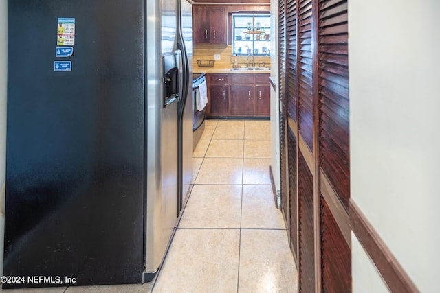 kitchen with stainless steel fridge, backsplash, light tile patterned floors, and sink