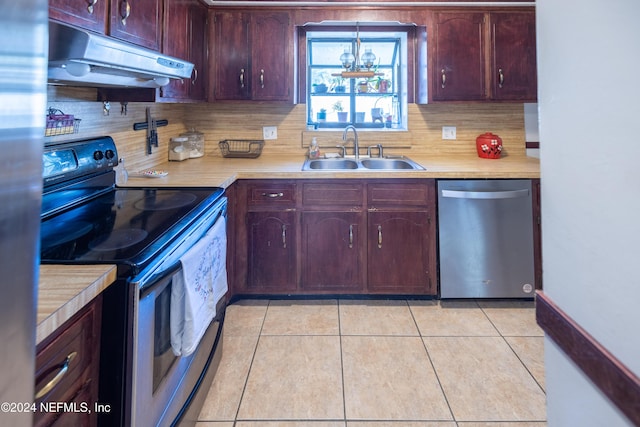 kitchen with light tile patterned floors, sink, appliances with stainless steel finishes, and tasteful backsplash