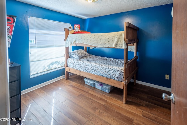 bedroom featuring wood-type flooring and a textured ceiling