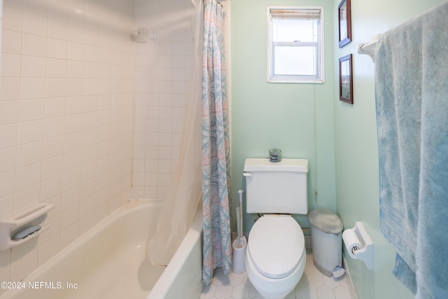 bathroom featuring tile patterned flooring, shower / bath combination with curtain, and toilet