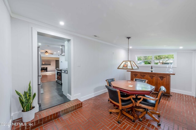 dining room featuring ornamental molding and a brick fireplace