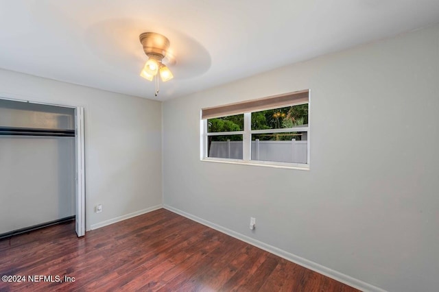 unfurnished bedroom featuring dark hardwood / wood-style floors, ceiling fan, and a closet