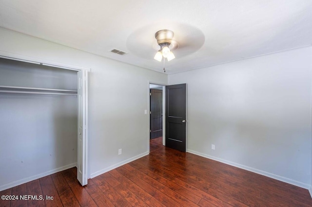 unfurnished bedroom with dark wood-type flooring, ceiling fan, and a closet