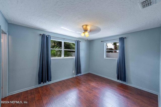 unfurnished room with ceiling fan, a textured ceiling, and dark hardwood / wood-style flooring