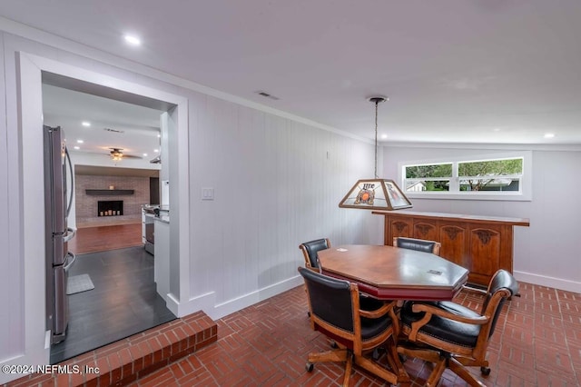 dining space featuring a fireplace and ornamental molding