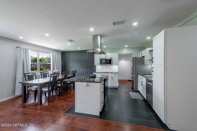 kitchen with white cabinetry, island range hood, a center island, stainless steel appliances, and backsplash