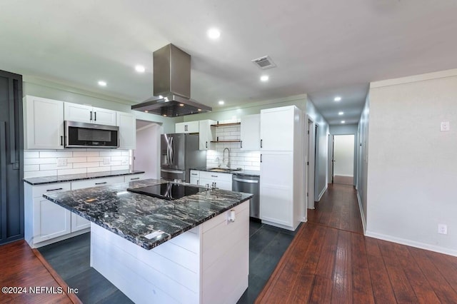 kitchen featuring island exhaust hood, appliances with stainless steel finishes, white cabinets, and backsplash