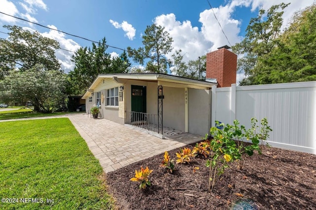 rear view of property featuring a lawn