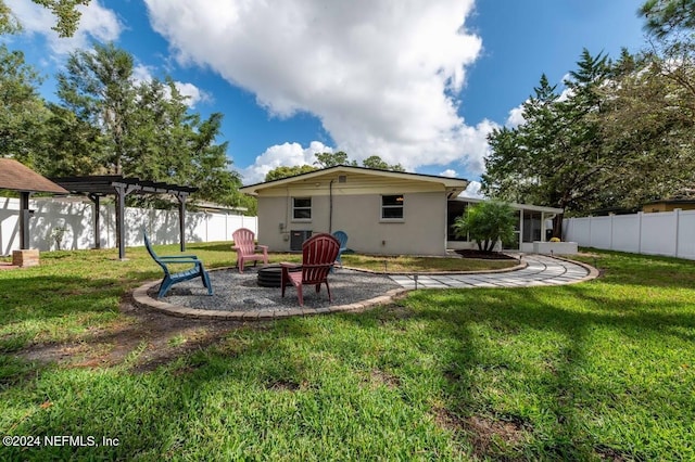 back of property with cooling unit, a pergola, a lawn, and an outdoor fire pit