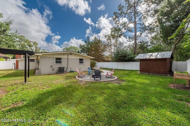 view of yard featuring a storage shed, a fire pit, and central air condition unit