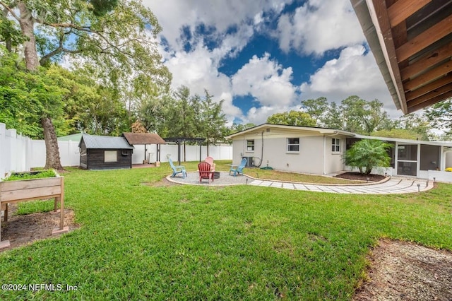 view of yard featuring a pergola, a fire pit, a sunroom, and a storage unit