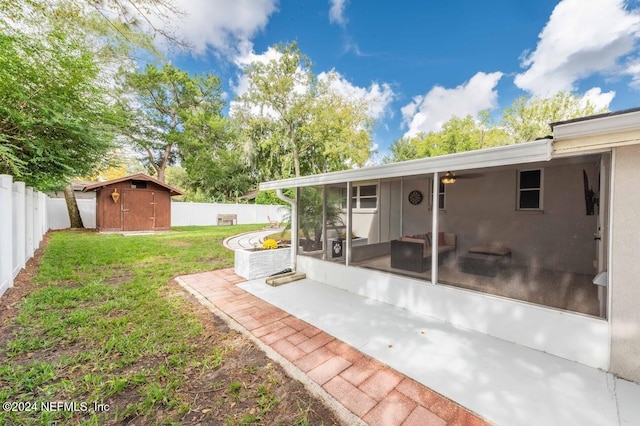 view of yard with a sunroom, a patio area, and a storage shed