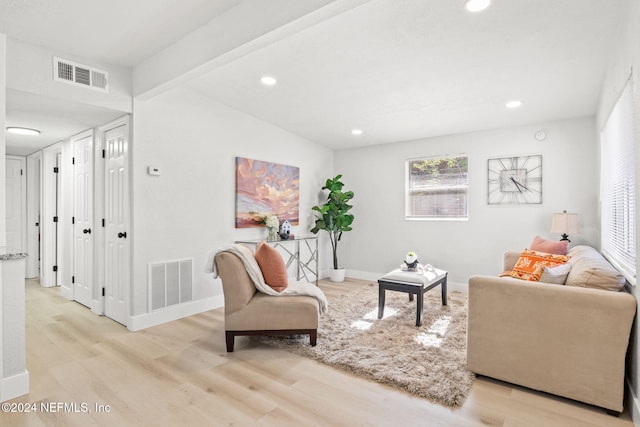 living room featuring beam ceiling and light wood-type flooring