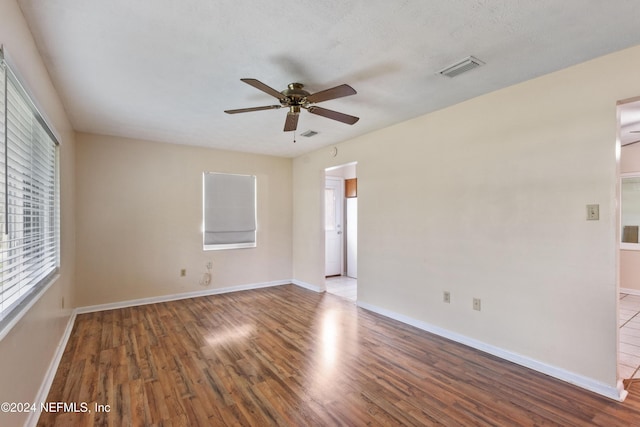 spare room featuring hardwood / wood-style flooring, ceiling fan, and a textured ceiling