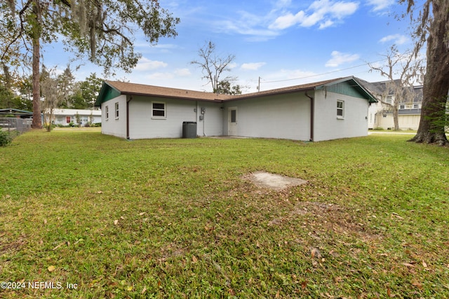 rear view of property with a yard and cooling unit