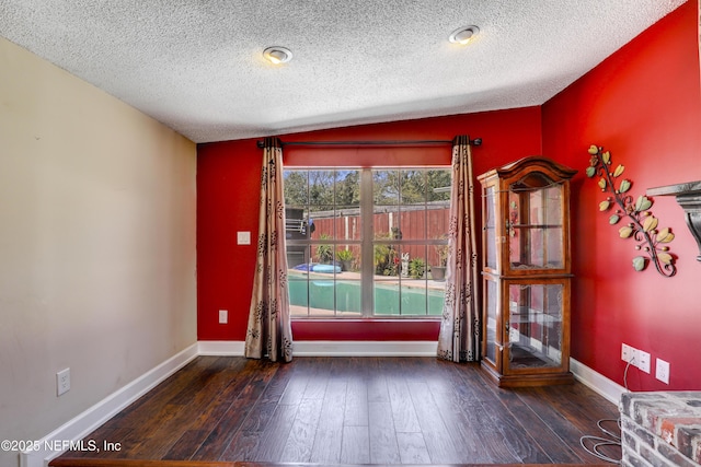 entryway with hardwood / wood-style flooring, baseboards, and a textured ceiling