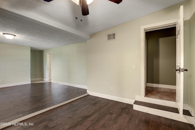 unfurnished room featuring visible vents, baseboards, wood finished floors, and a ceiling fan