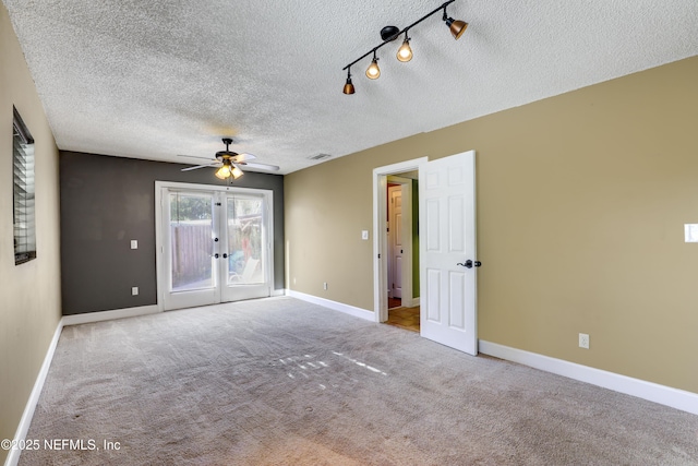 carpeted empty room featuring visible vents, baseboards, french doors, a textured ceiling, and a ceiling fan