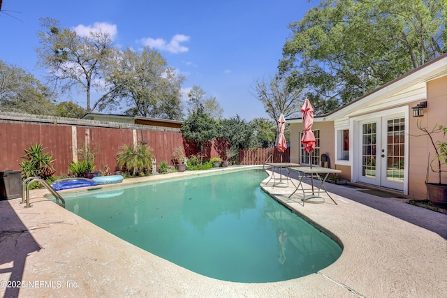 view of pool with a patio area, a fenced in pool, french doors, and a fenced backyard